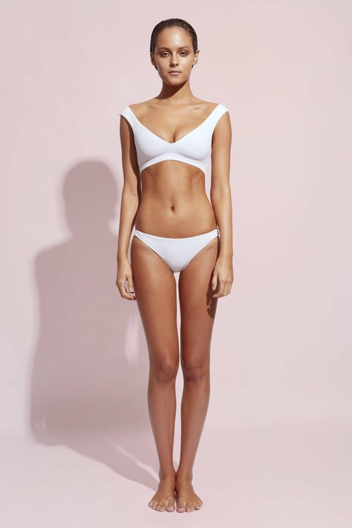White low-rise bikini bottom with moderate cheeky cut, seamless construction, classic beach swimwear